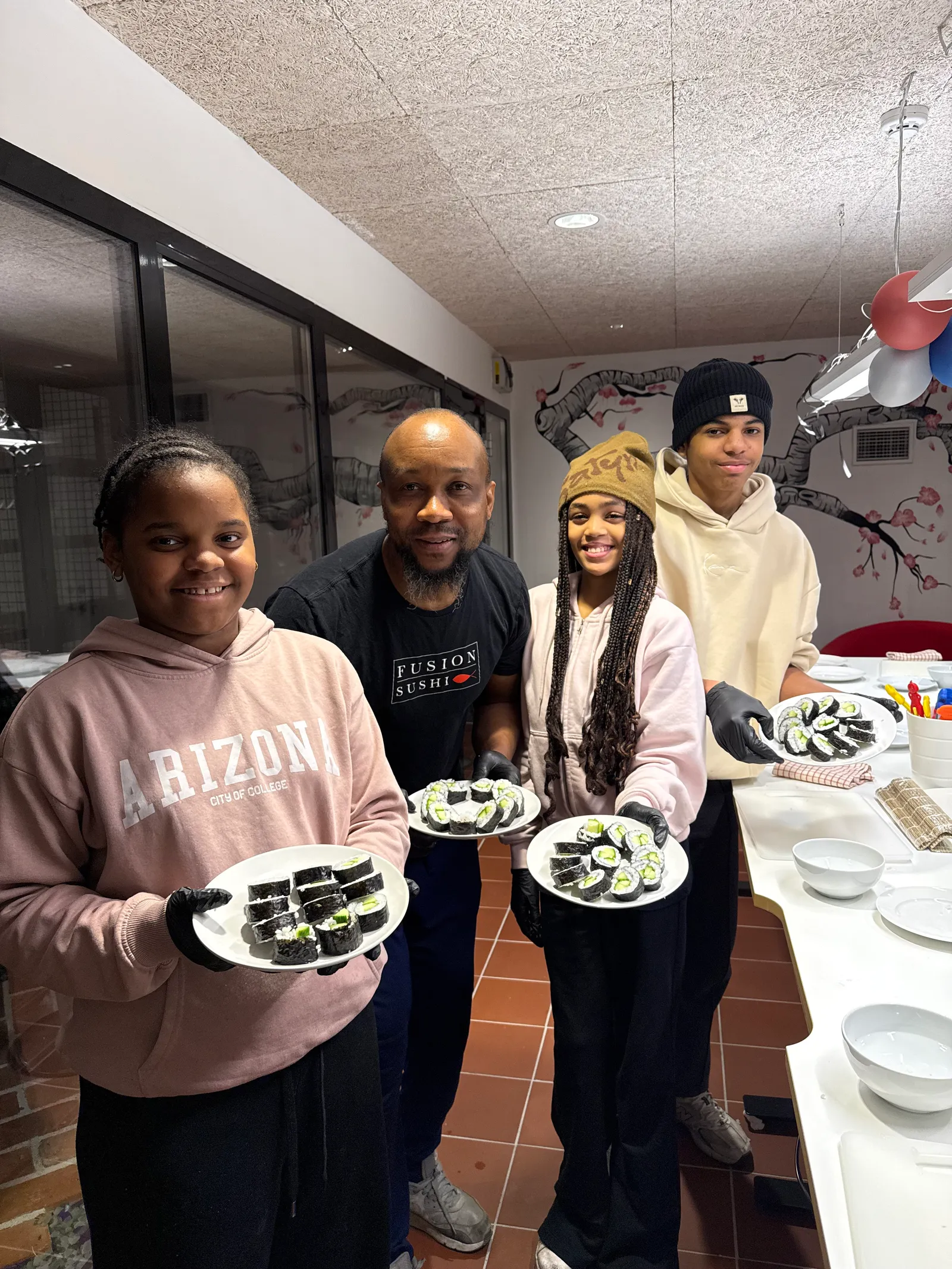 Participants and Chef Kassim with plates full of their own hand-rolled sushi