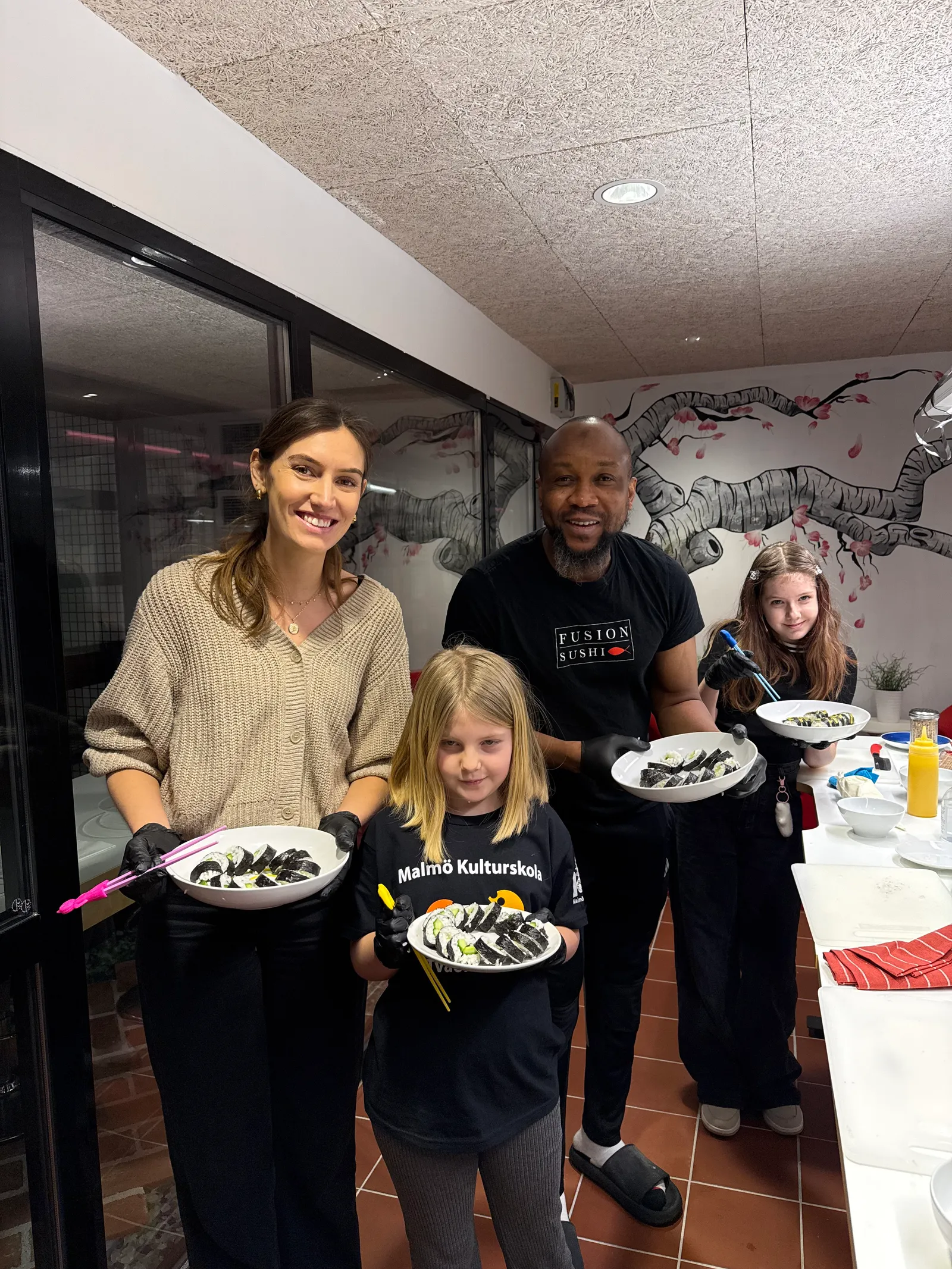 A family with their plates of sushi after the class